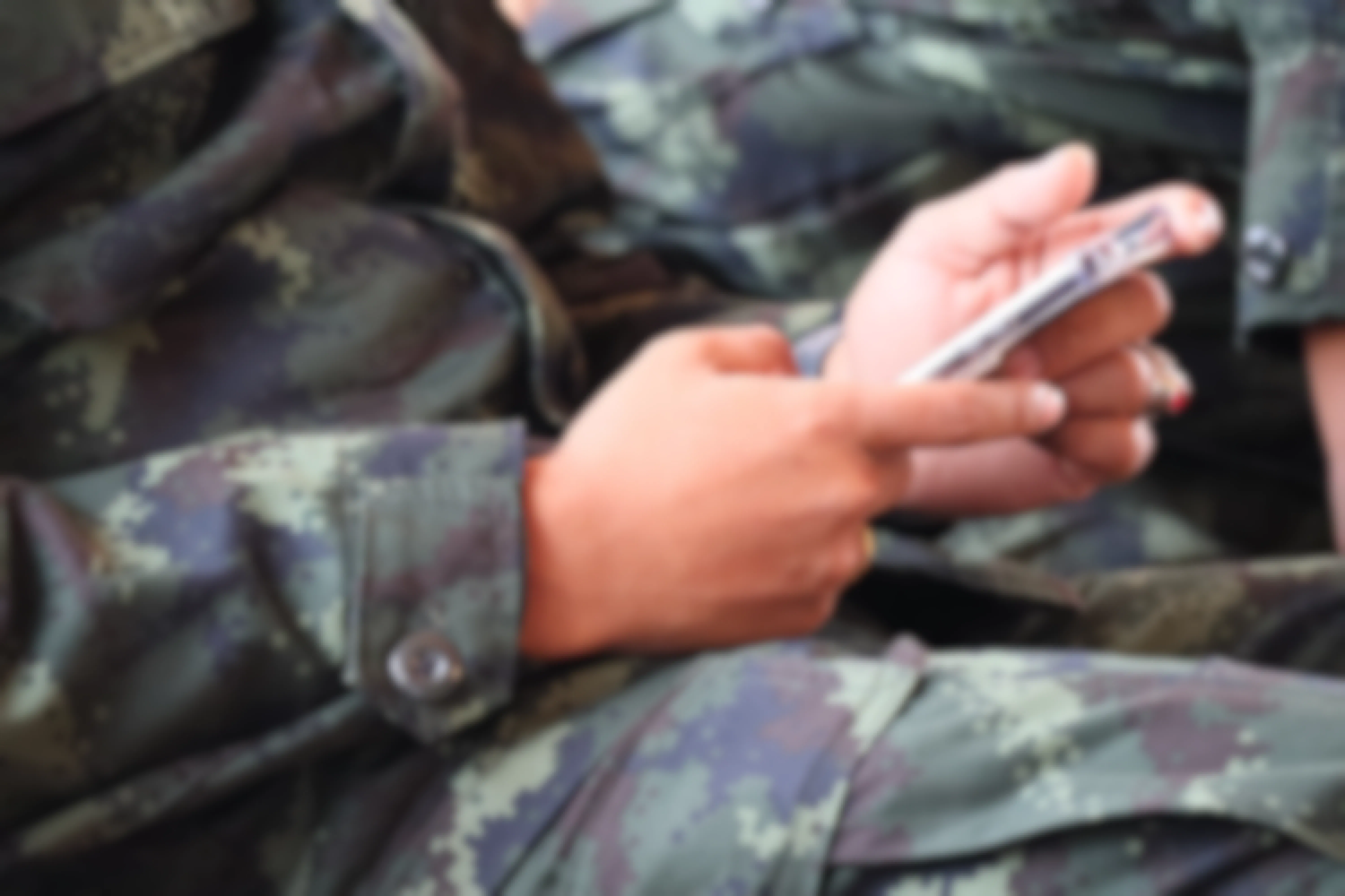 Person in uniform on smart phone