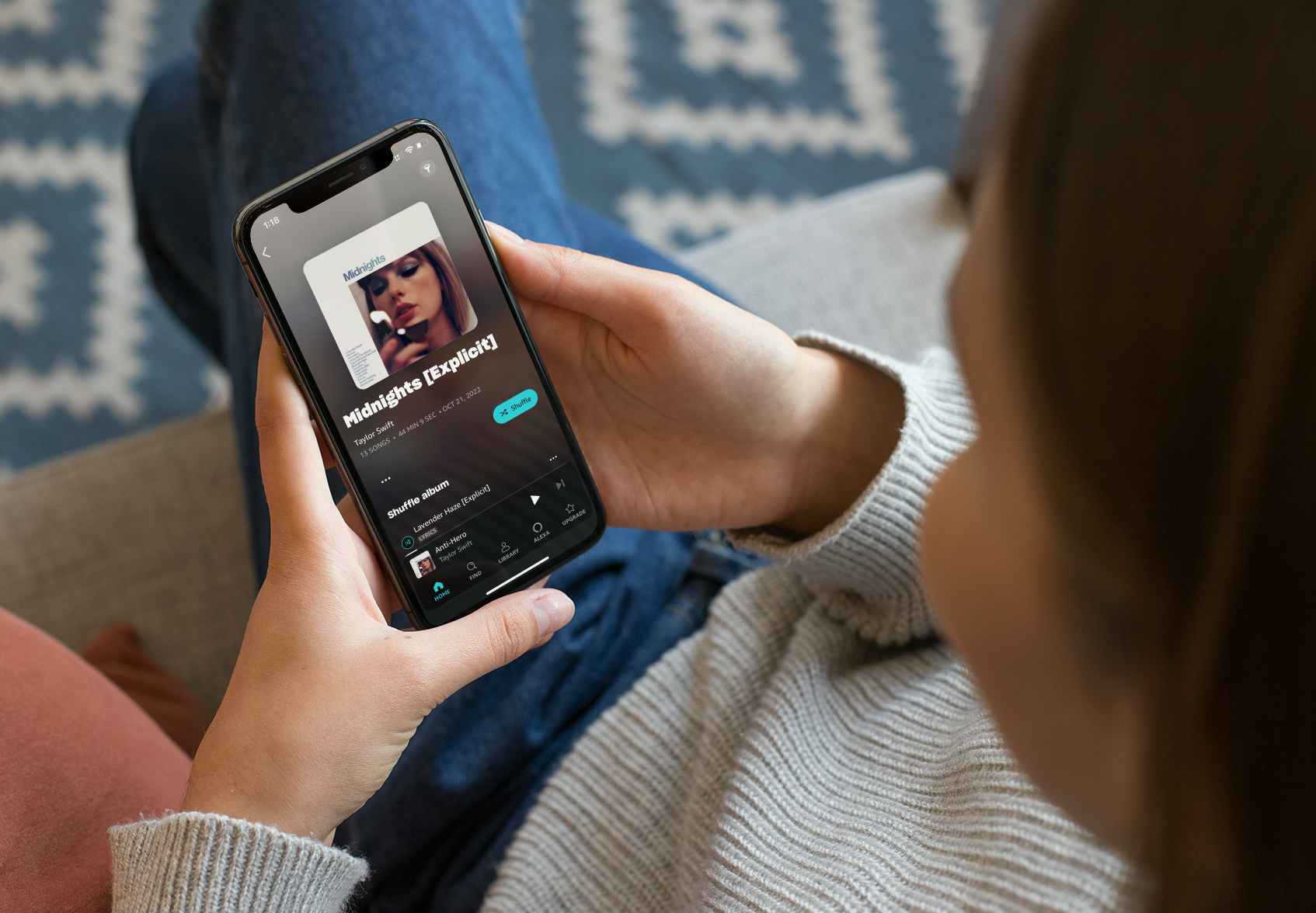 Woman looking at Amazon Music free on her phone, ready to shuffle Midnights by Taylor Swift