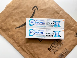 tubes of sensodyne toothpaste over an amazon package