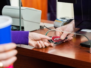 person receiving purchased movie tickets at amc theatre counter