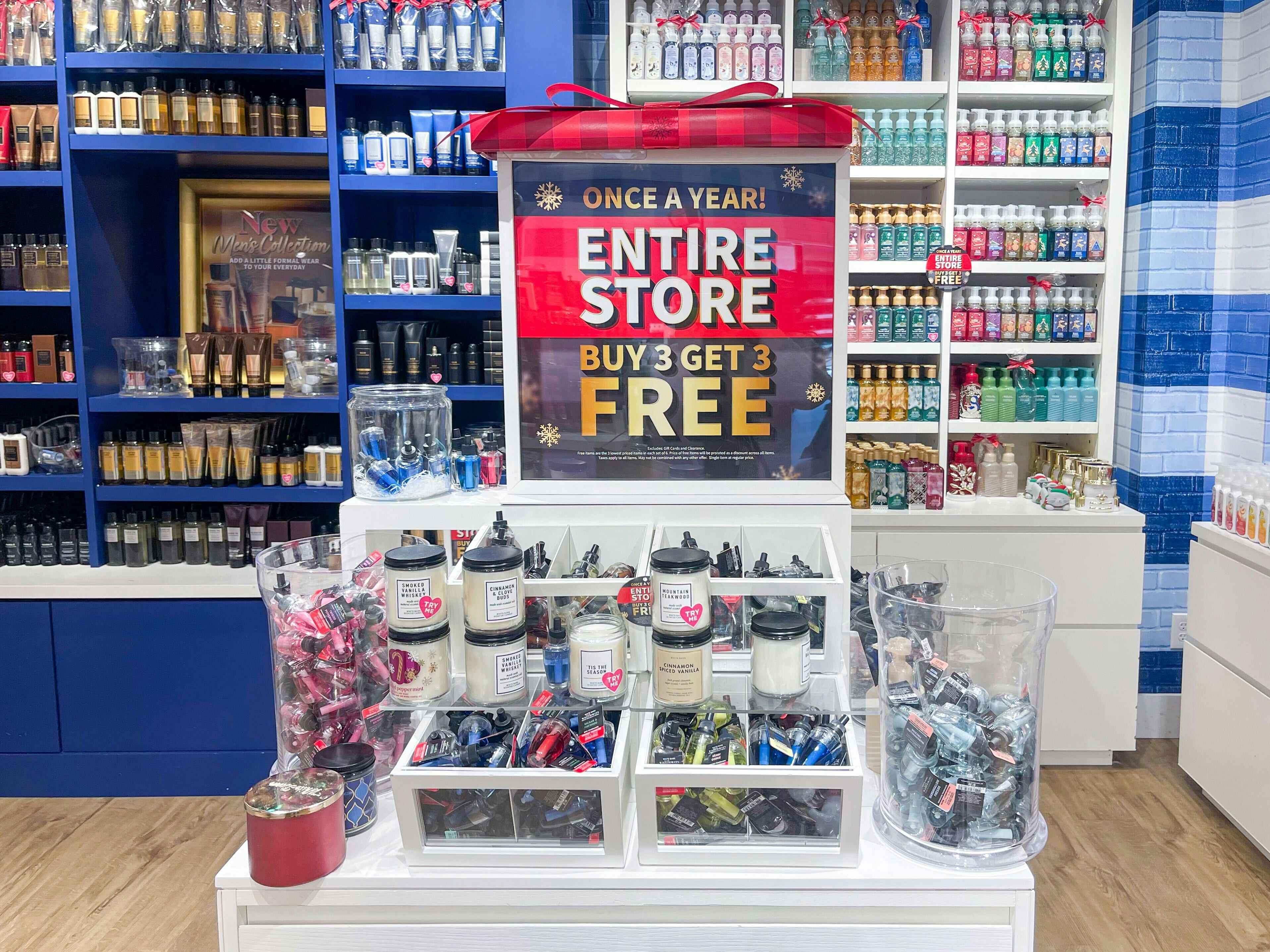 the black friday sale sign inside Bath and Body Works that says: ONCE A YEAR! ENTIRE STORE BUY 3 GET 3 FREE