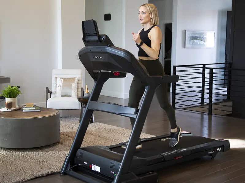 A person walking on a Sole f63 treadmill in their home