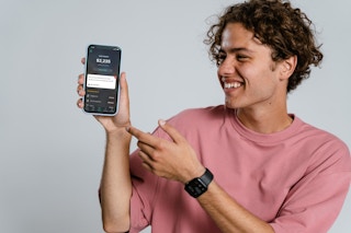 Person holding up an phone show the Pocket Guard App
