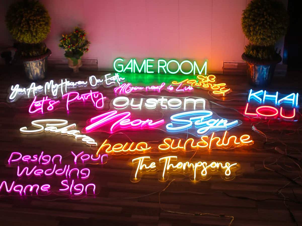 Different custom neon signs together on a floor