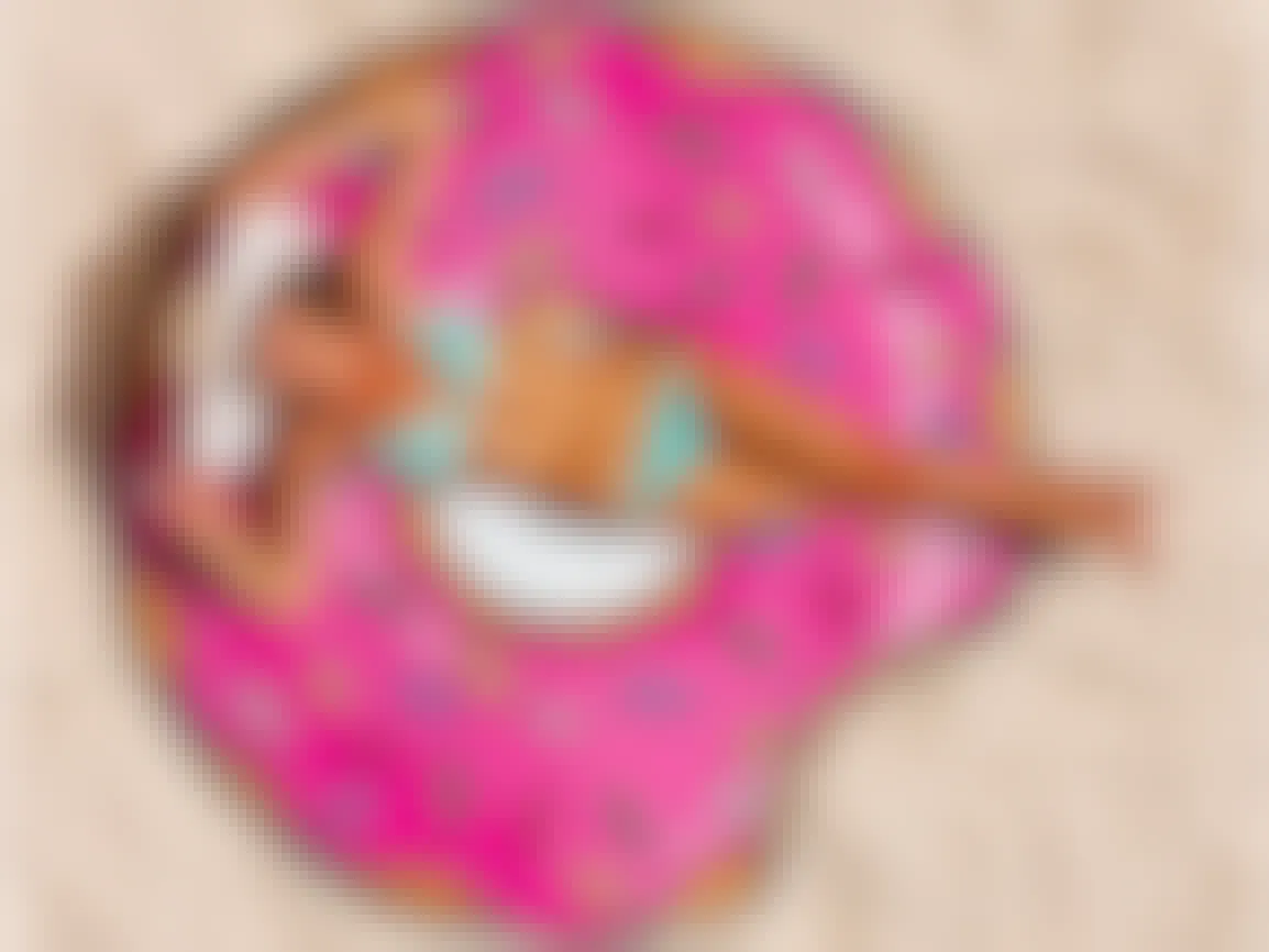 gifts for teens - A person laying on a beach towel shaped like a doughnut with sprinkles