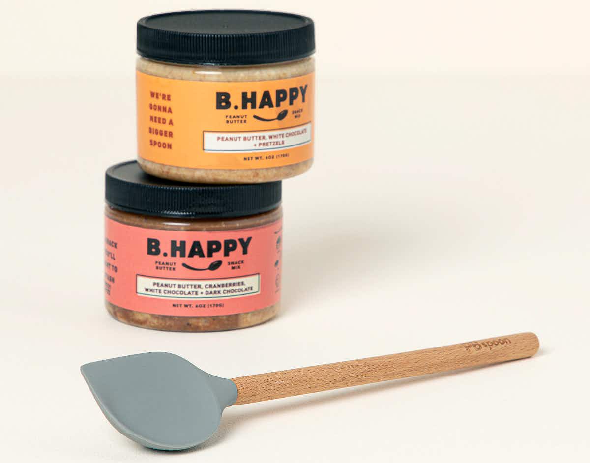 best stocking stuffer ideas - A special Peanut Butter Spoon next to some jars of peanut butter on a neutral background