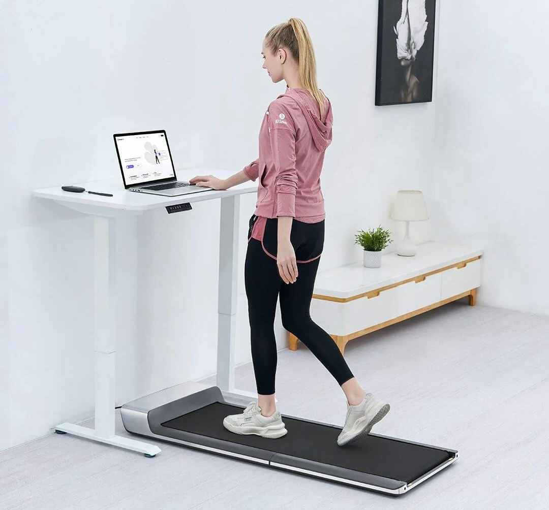 A person walking on a WalkingPad under-desk treadmill in their home office