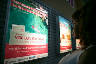 Person with curly hair looking at a BJ's Member offer