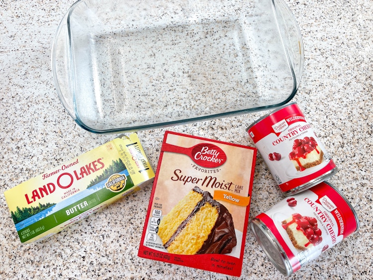 ingredients to make a cherry dump cake on a counter 