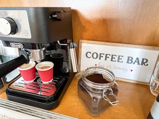 an expresso maker brewing coffee at a home coffee bar