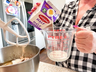a person pouring half and half in a measuring cup