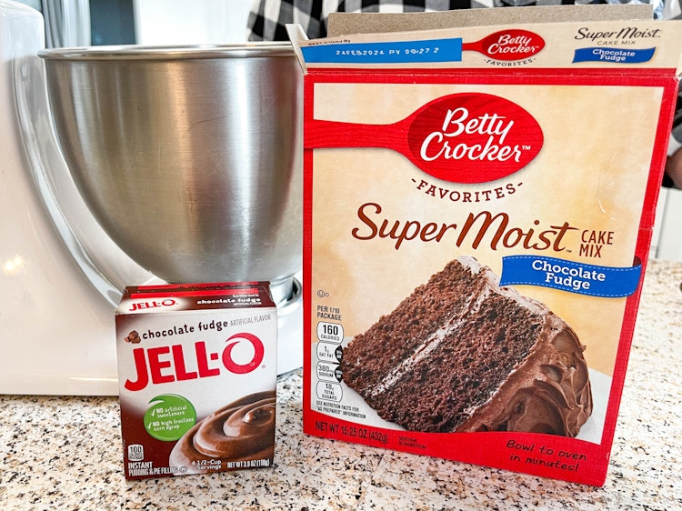 boxed cake mix and jello pudding mix sitting on the counter next to mixer 