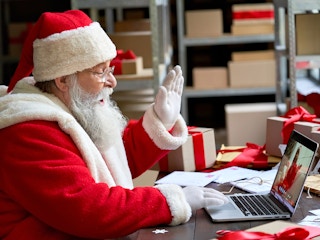 santa claus waving to someone on laptop video call