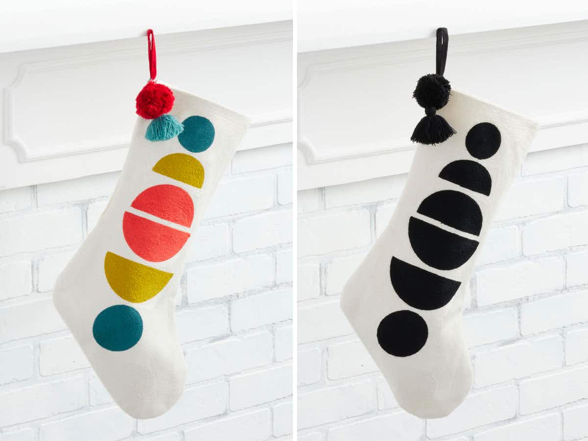 Geometric Half Circle Christmas Stockings, one colorful and one black and white, hanging off a mantel