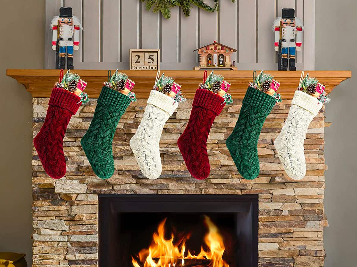 A 6-pack of Kunyida 18-Inch Knitted Christmas Stockings hanging above a fireplace