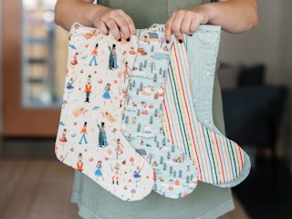 best christmas stockings - A person holding 3 Tabknits Quilted Christmas Stockings
