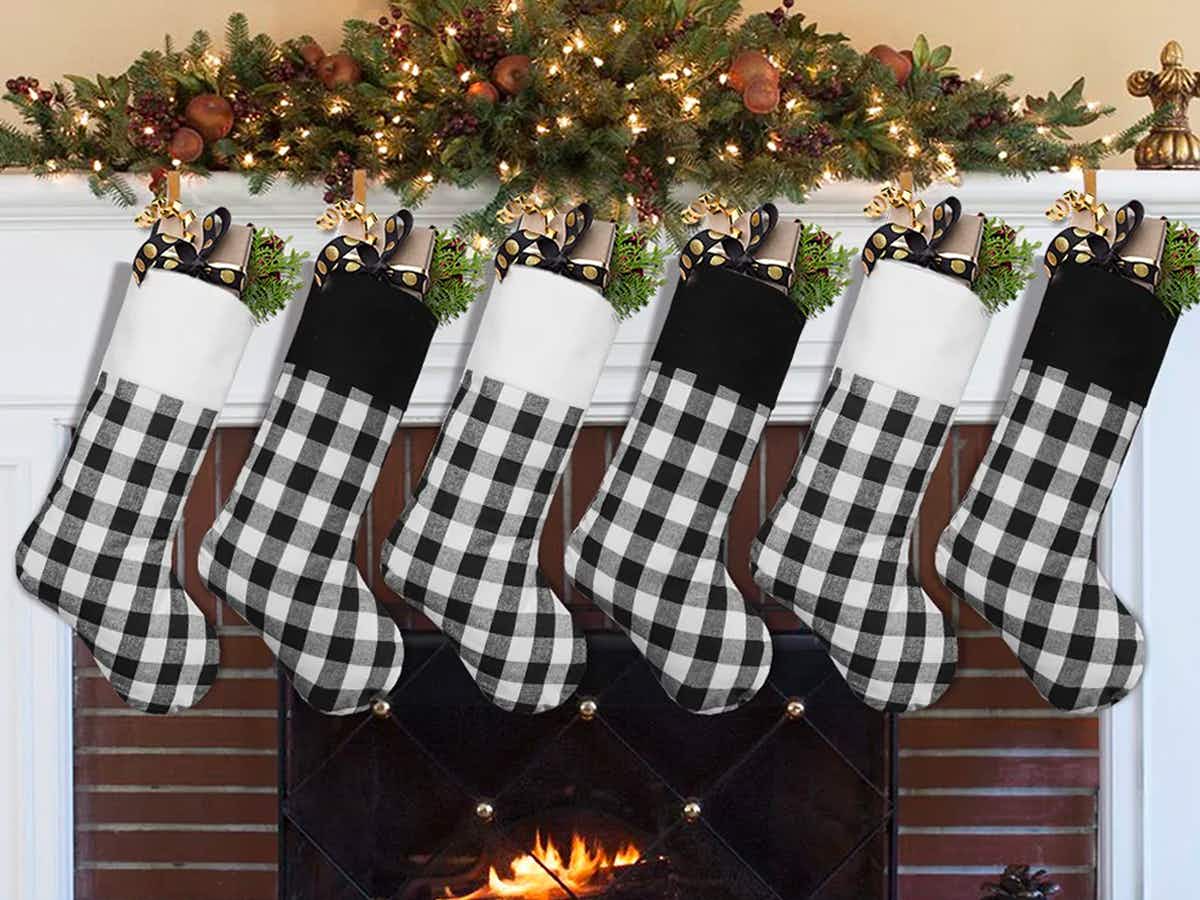A set of 6 The Holiday Aisle plaid stockings hanging above a fireplace