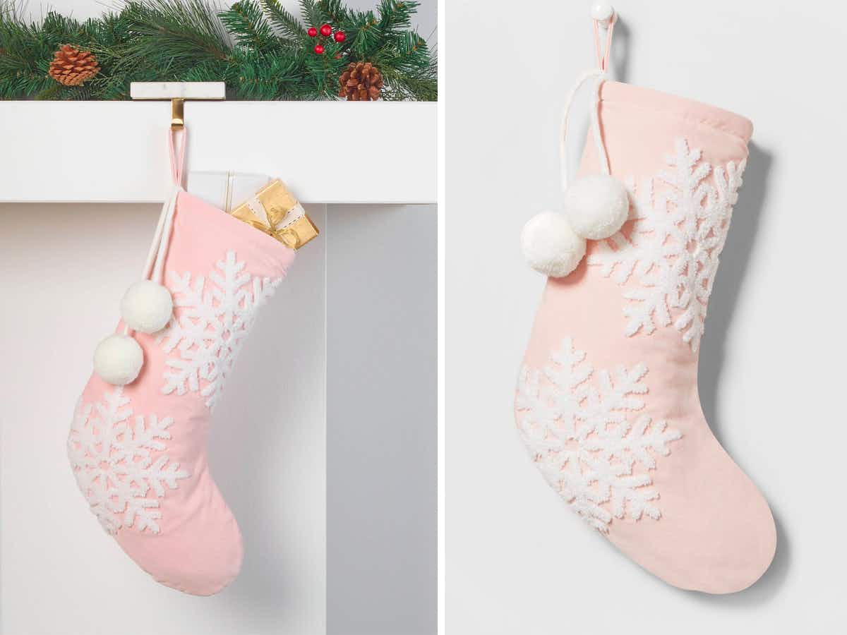 A Wondershop Velvet Christmas Stocking with Snowflakes hanging from a mantel and on a grey background