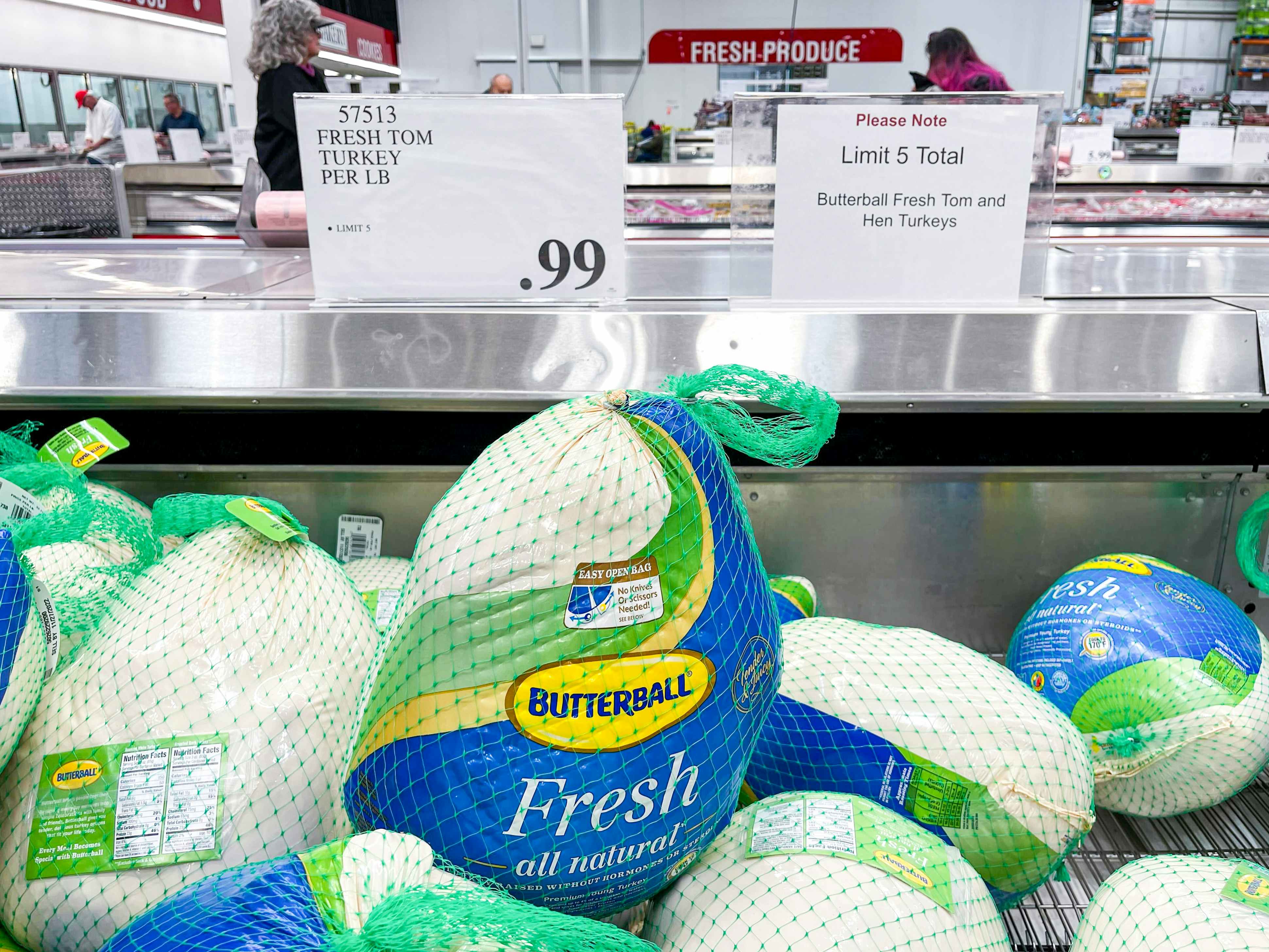 Whole Fresh Butterball turkeys in the refrigerated meat section of Costco with a sign showing them to be 99 cents per pound and another sign that reads, "Please Note, Limit 5 Total, Butterball fresh tom and hen turkeys
