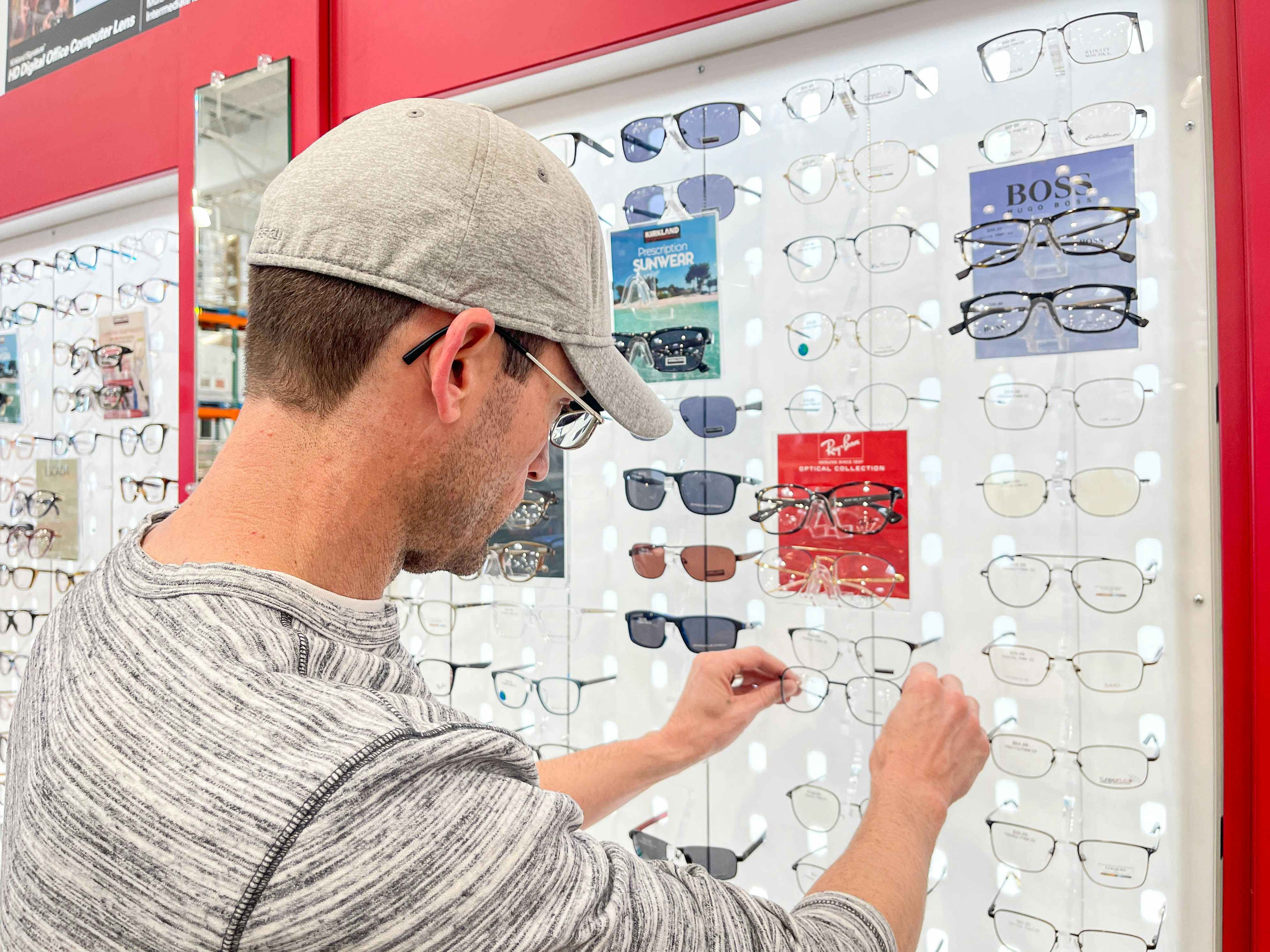 a man looking at costco optical eyeglasses on display 