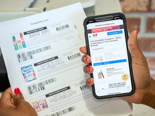 person holding phone with coupons.com brands and offers and printed coupons