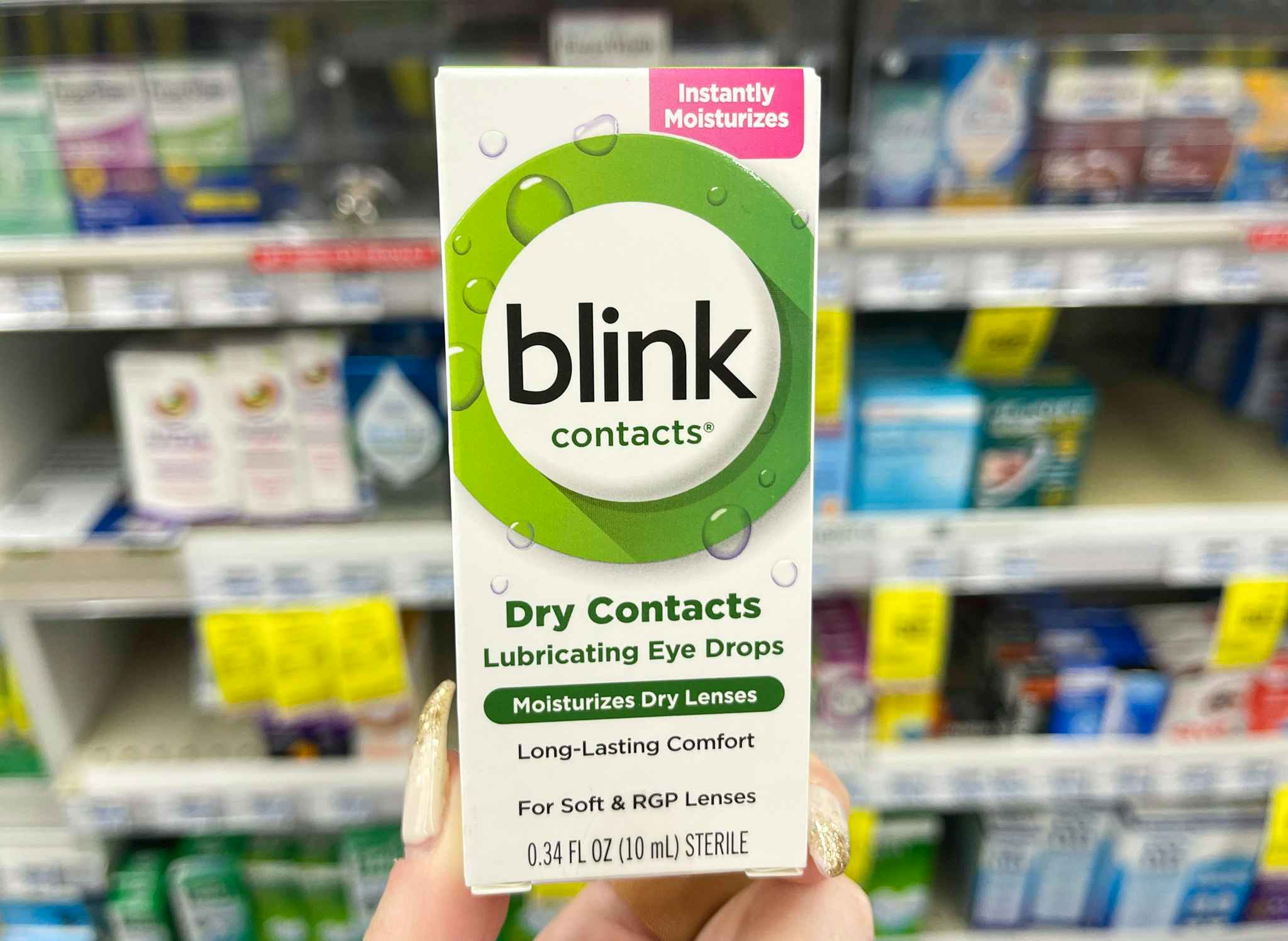 hand holding blink contacts in front of shelf