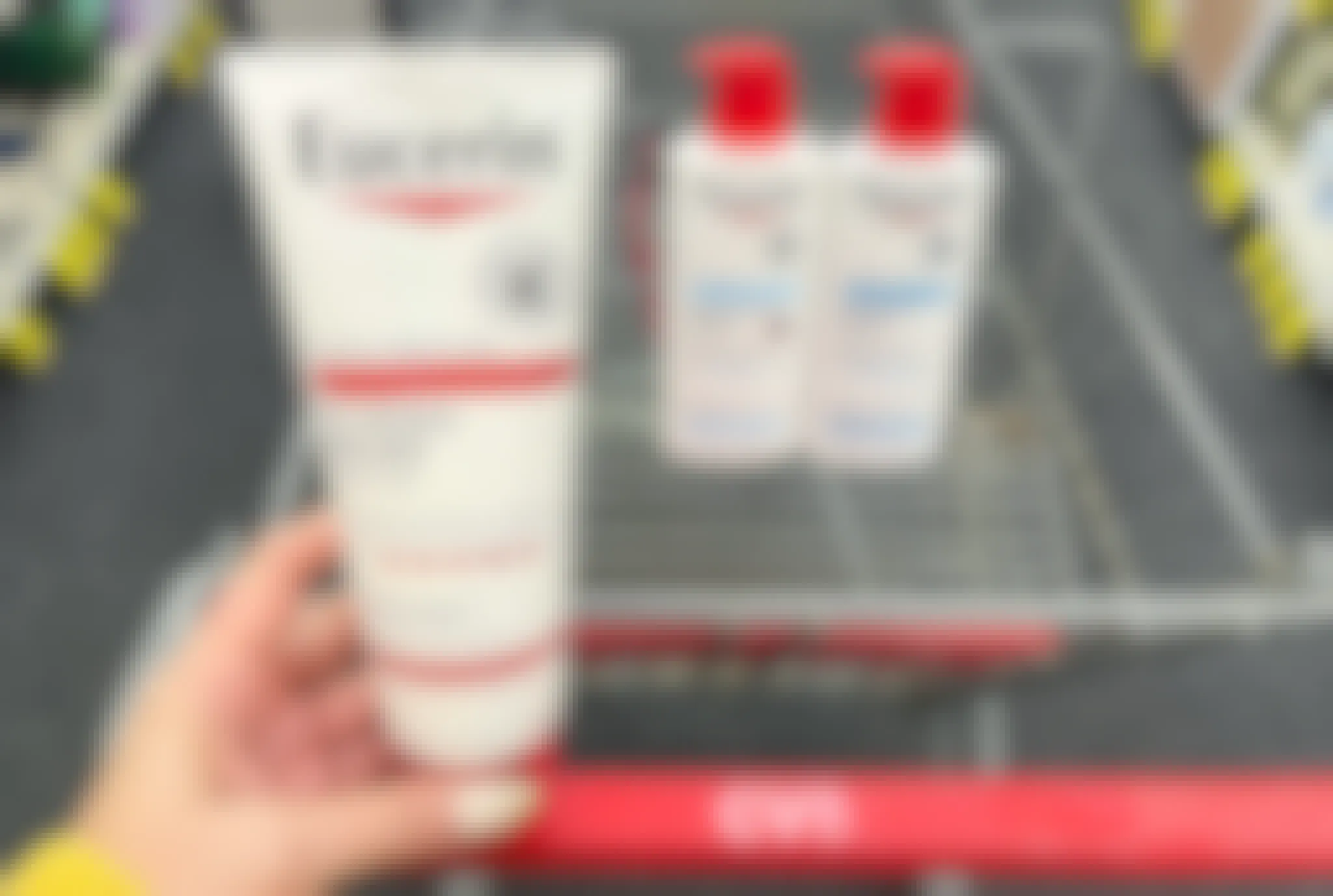 hand holding eucerin lotion in front of cvs cart