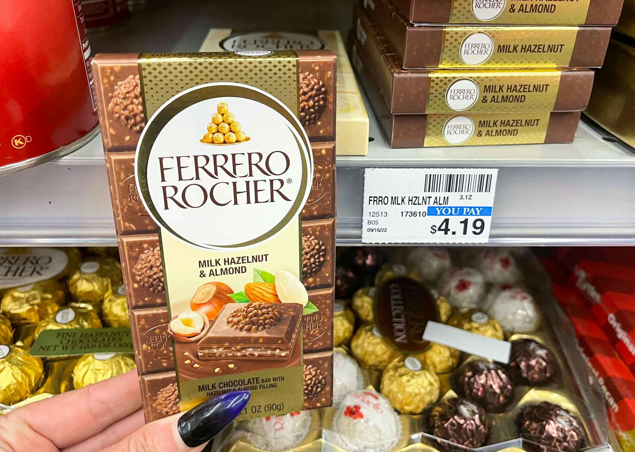 hand holding ferrero rocher bar next to price tag