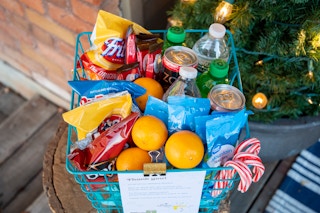 Thank you sign attached to a basket full of treats on a front porch
