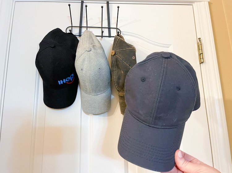 a person's hand putting a hand on a over the door rack