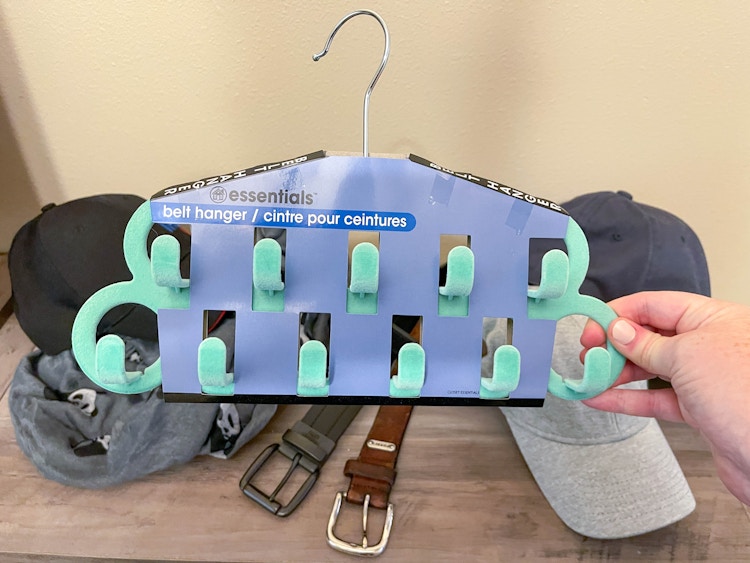 a person holding a dollar tree belt hanger 