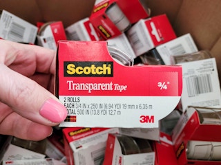 A person holding a roll of Scotch tape.