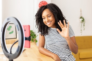 Influencer-Looking at phone through ring light