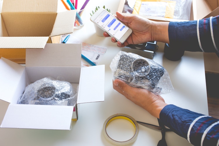 Young person wrapping product into a box
