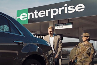 An Enterprise employee showing a vehicle to someone in military uniform