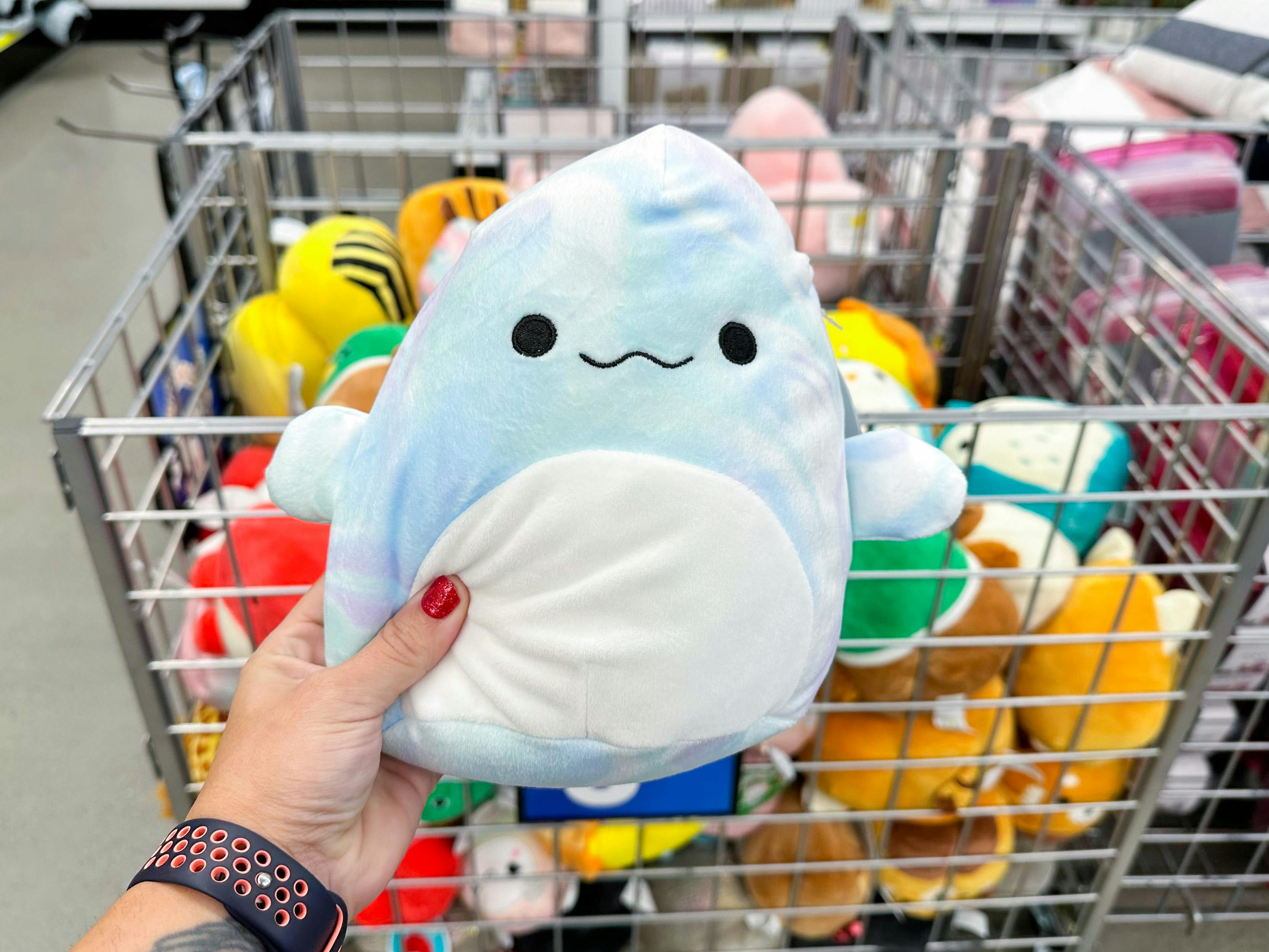Someone holding up a beluga whale Squishmallow in Five Below