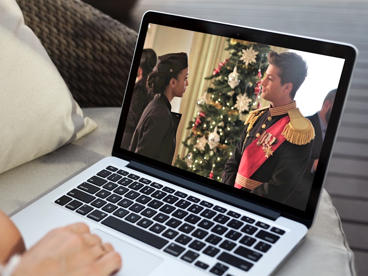person watching a holiday movie on laptop