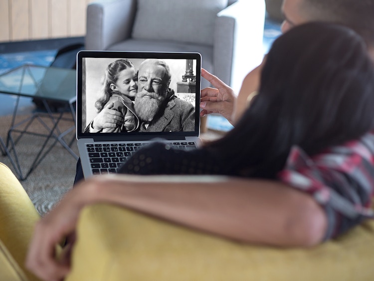 couple on couch watching Miracle on 34th Street on laptop