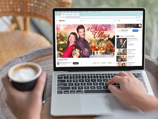 person at laptop watching christmas movie on youtube