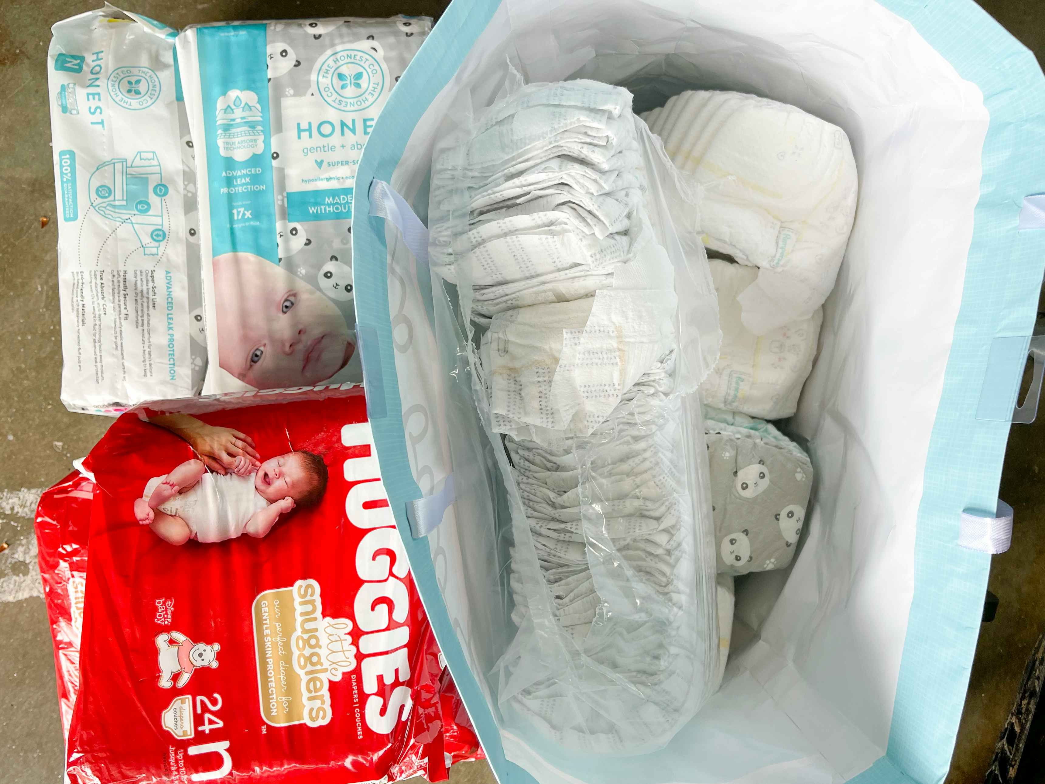 Opened pack of different brands of diapers in tote bag 