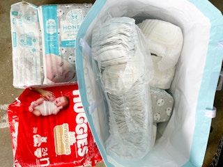 Opened pack of different brands of diapers in tote bag 
