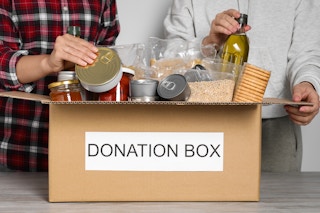 People putting food into a donation box