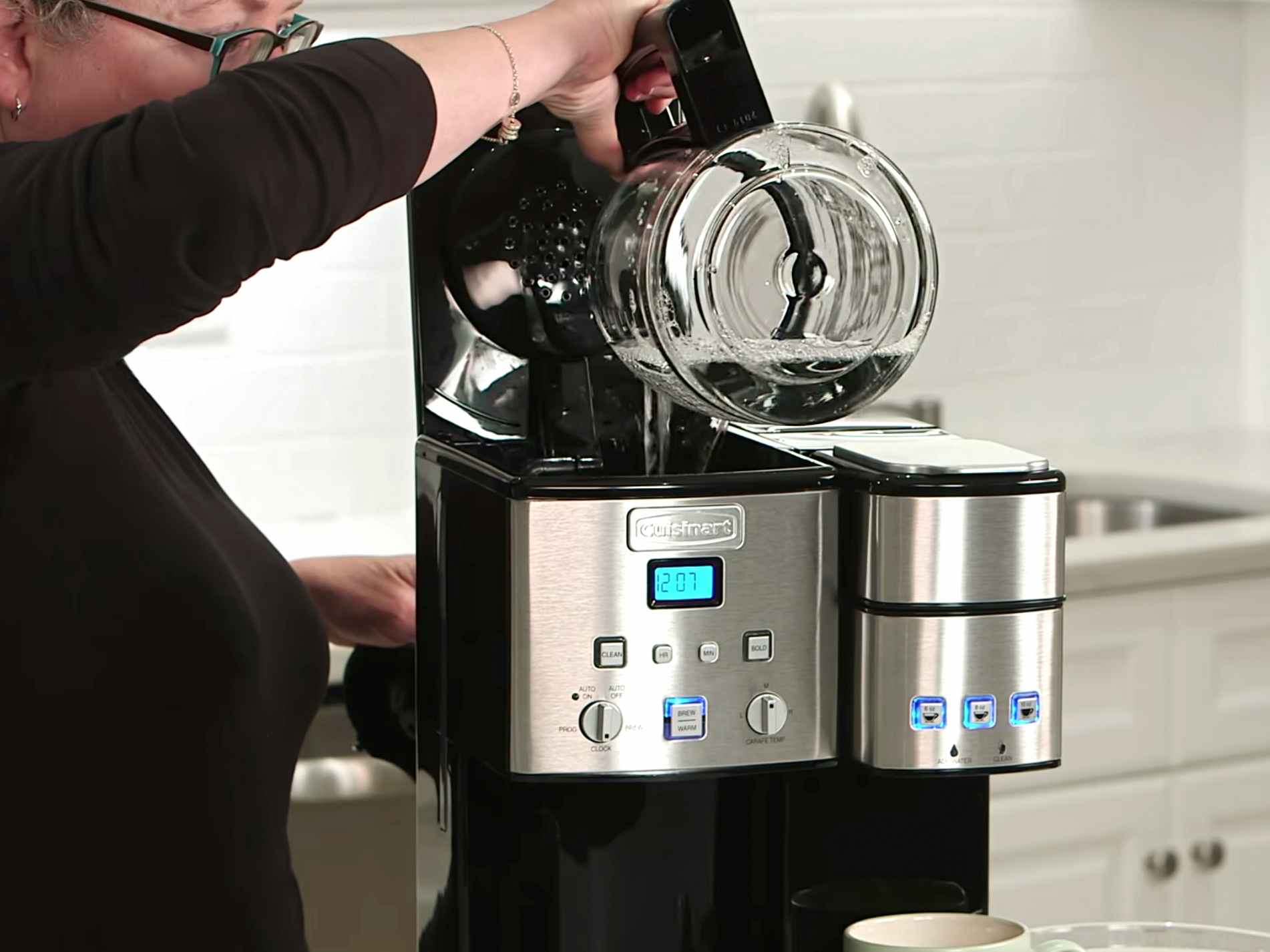 person cleaning a cuisinart coffee maker with water-vinegar solution