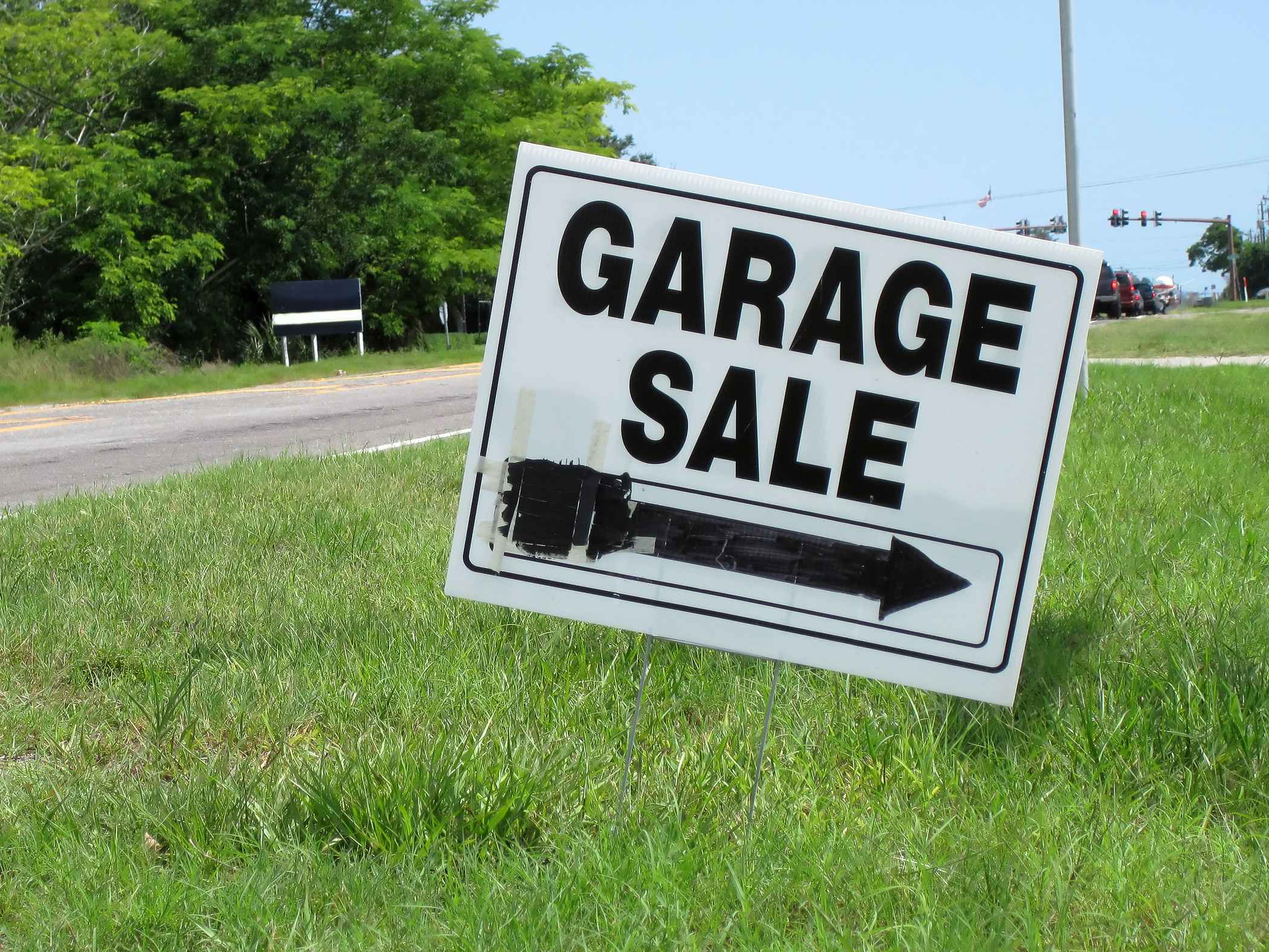 A Garage Sale sign on a curb with an arrow pointing to the right