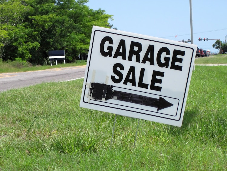 A Garage Sale sign on a curb with an arrow pointing to the right