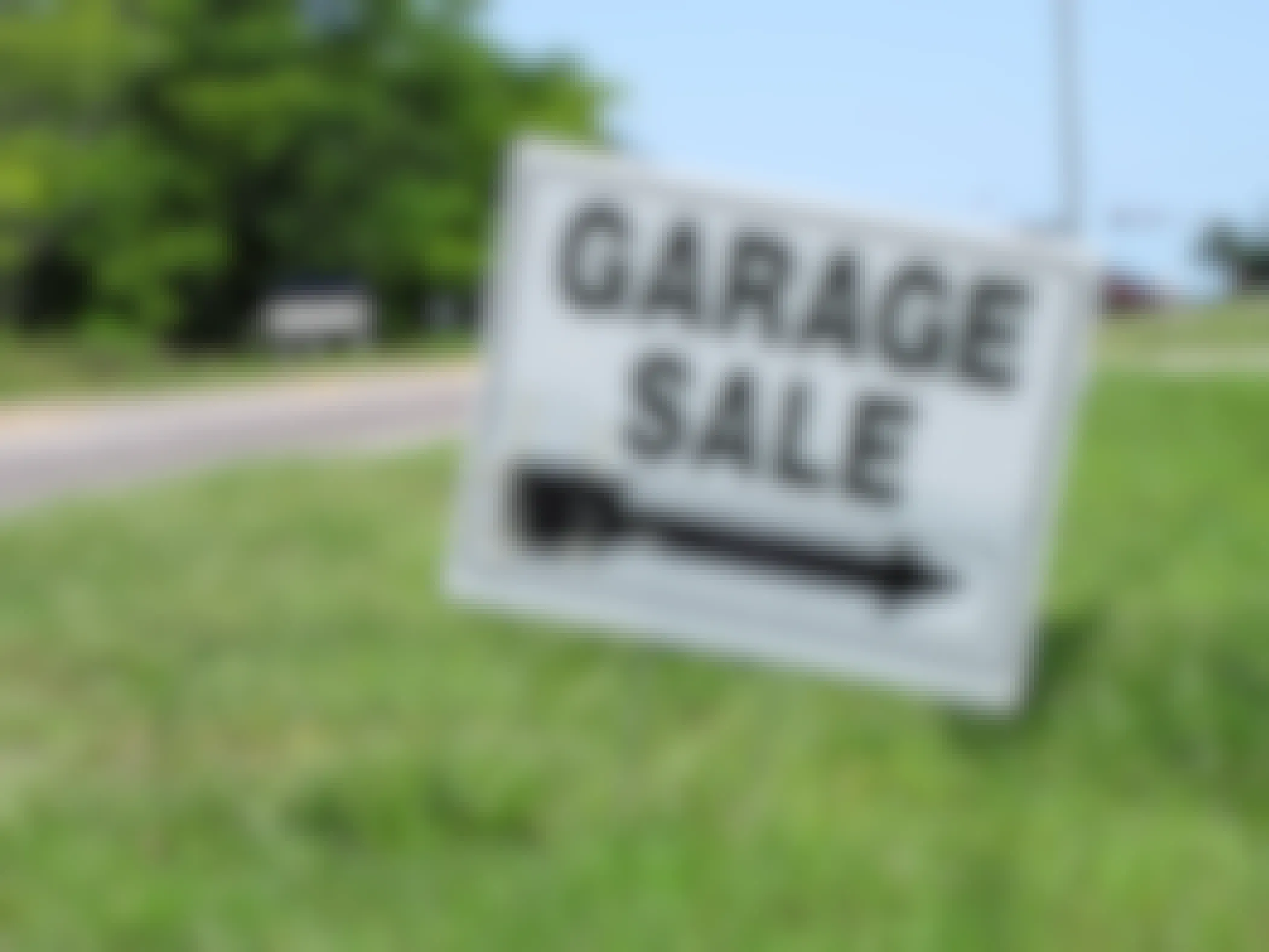 A Garage Sale sign on a curb with an arrow pointing to the right