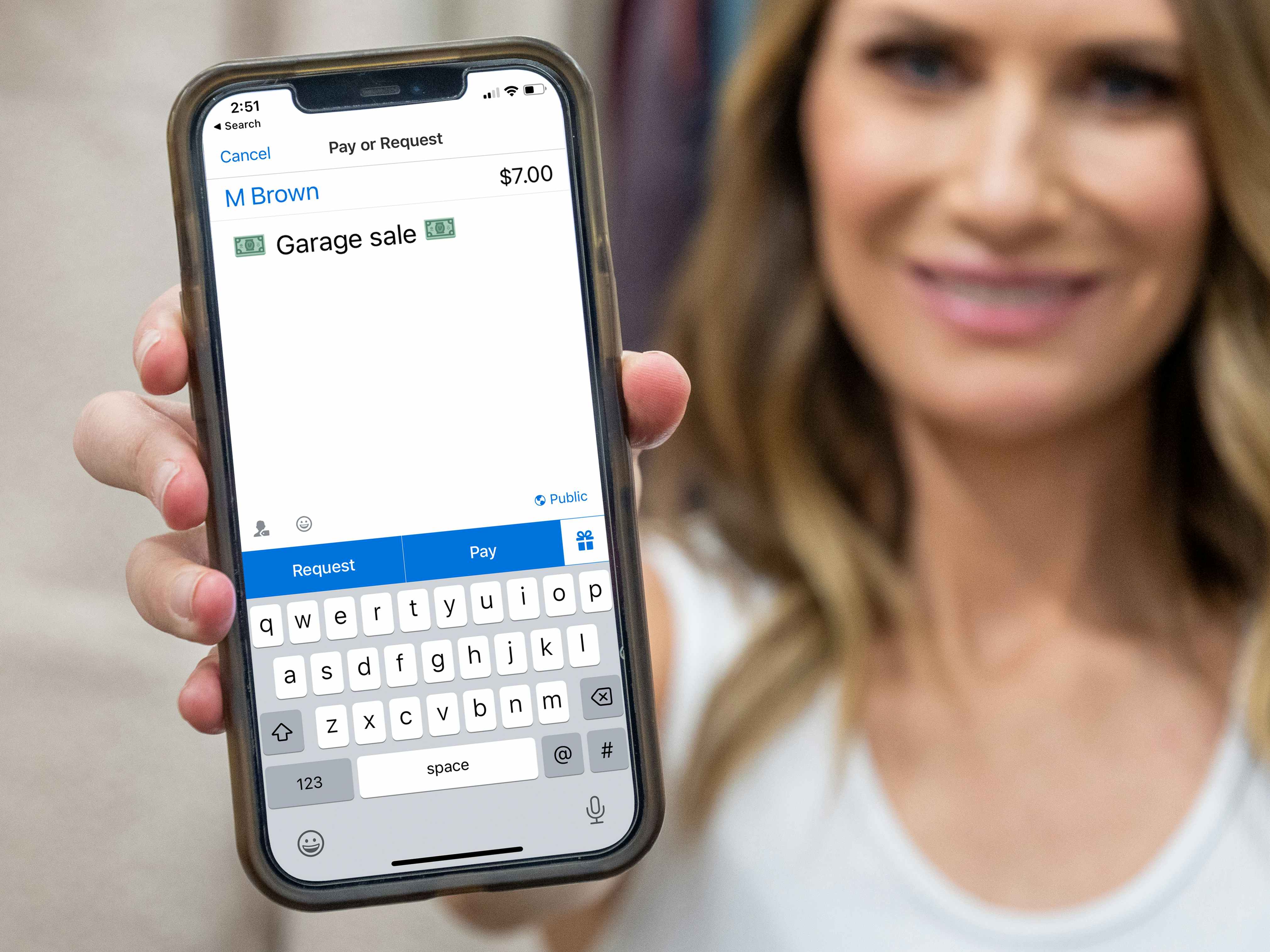 A person holding up a phone displaying a Venmo payment screen