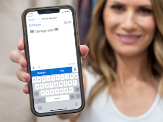 A person holding up a phone displaying a Venmo payment screen