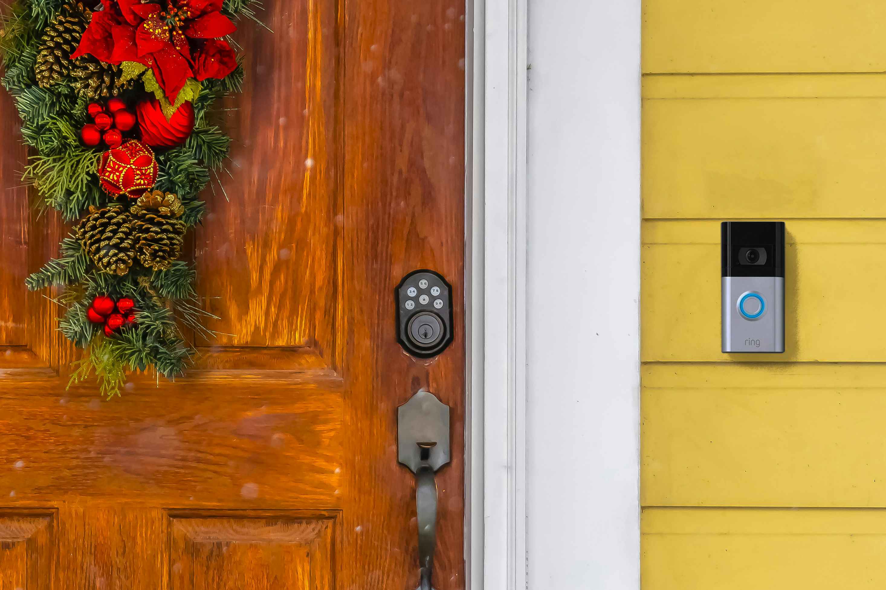A Ring doorbell outside of a front door that is decorated for Christmas