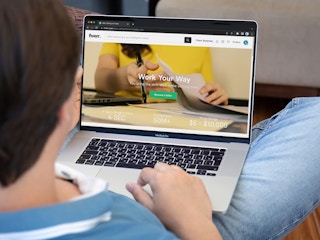 A teen looking at the Fiverr website on a laptop